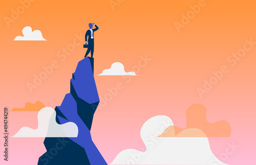 Uomo d'affari sulla cima del monte che guarda verso il futuro per nuove opportunità