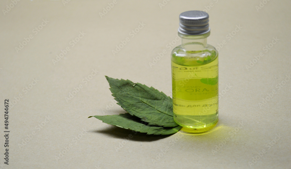 Bottle with green gel and two leaves from wood on a craft background. Bottle with green gel and two leaves from wood on a craft background.