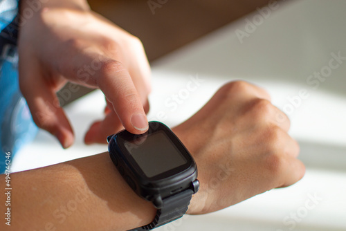 Wallpaper Mural Close-up - little boy touching button and touchscreen on smartwatch. Finger touch button on smarth watch. Torontodigital.ca