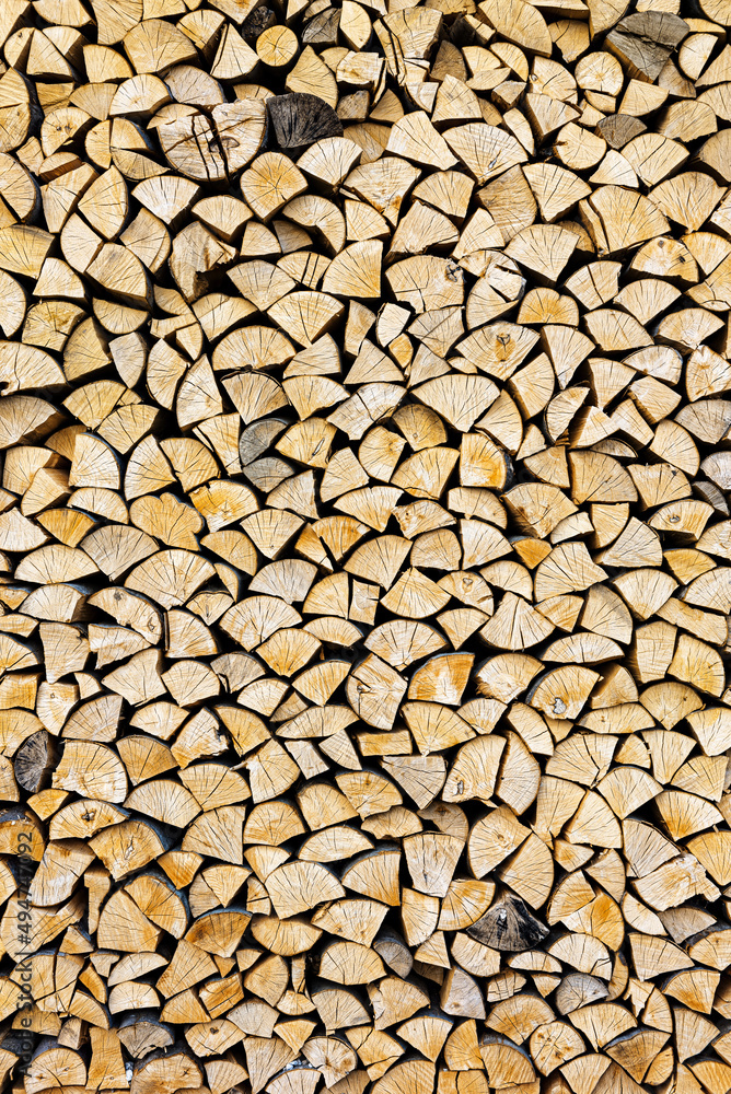 Stacked chopped wood close-up texture. Firewood storage background. Stocks of wooden logs. Chopping wood for a fireplace. Woodpile with firewood with visible wooden texture. Stacked chopped wood close-up texture. Firewood storage background. Stocks of wooden logs. Chopping wood for a fireplace. Woodpile with firewood with visible wooden texture.