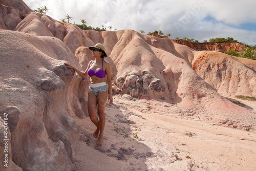 Fit Woman standing at the Colorful Red Cliffs known as the Falesias near Arraial d’ Ajuda, Bahia, Brazil

 photo