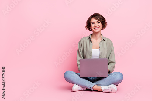 Full size photo of cheerful charming lady sit look camera toothy smile isolated on pink color background