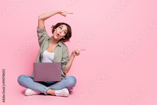 Full length photo of astonished lady pouted lips look direct fingers empty space isolated on pink color background