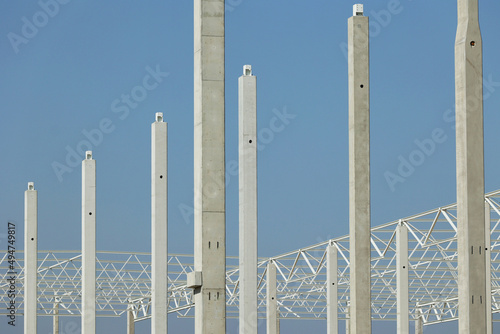 Biała stalowa konstrukcja hali magazynowej w czasie budowy.
