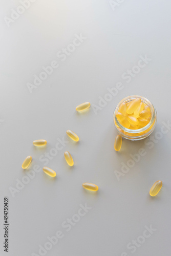 Yellow capsules of dietary supplements, vitamins, omega or other medicines top view on a solid background. The concept of health and medicine production. 