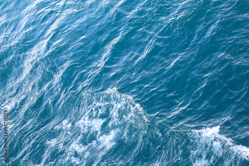 Water surface. Wake waves on the blue sea