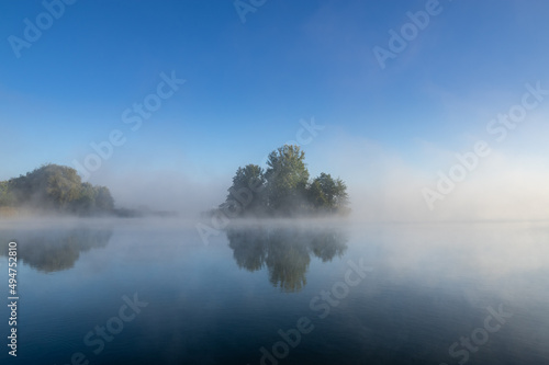 island in the lake on a foggy autumn morning