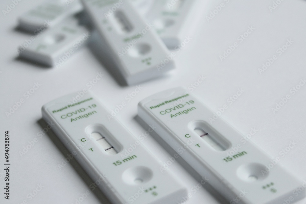 Positive and negative Covid-19 coronavirus rapid response antigen tests in white plastic boxes on clear sterile background, contagious infection testing at home during world pandemic. Positive and negative Covid-19 coronavirus rapid response antigen tests in white plastic boxes on clear sterile background, contagious infection testing at home during world pandemic.