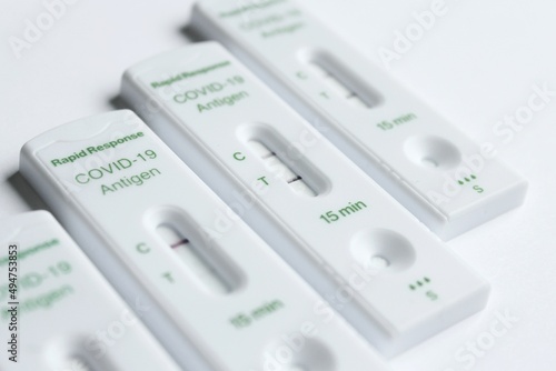 Positive and negative Covid-19 coronavirus rapid response antigen tests in white plastic boxes on clear sterile background, contagious infection testing at home during world pandemic.