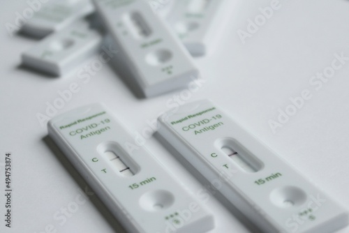 Positive and negative Covid-19 coronavirus rapid response antigen tests in white plastic boxes on clear sterile background  contagious infection testing at home during world pandemic.