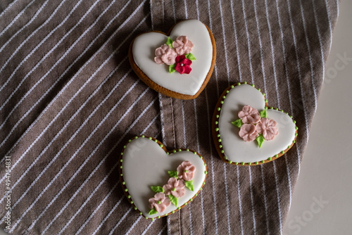 White gingerbread cookies with icing and flower decoration on a striped towel. Background for International Women's Day or Valentine's Day. High quality photo