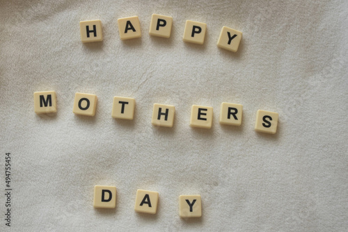 Happy mother's day, written with scrabble / bananagram block letters on soft white fleece background