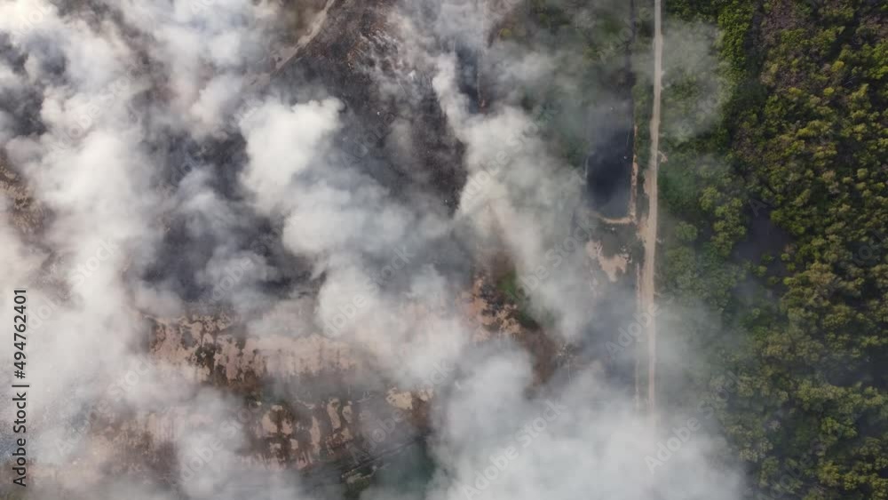 Aerial view look down smoke due to fire in landfill blown by wind cause air pollution to surrounding Aerial view look down smoke due to fire in landfill blown by wind cause air pollution to surrounding
