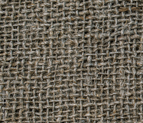 Sack texture background. Textile burlap background. Close-up photo of burlap. The texture of the fibers and threads of the coarse fabric. Textile abstraction. Textile brown background