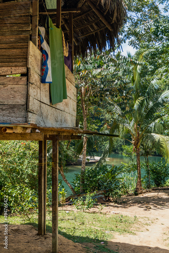 Embera Puru Embera village in Panama. A traditional Emberá house is an open-air dwelling raised off the ground on stilts, thatched roofing made from palm leaves. photo