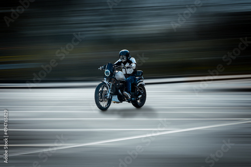 Biker on a motorcycle on the road in motion from the side