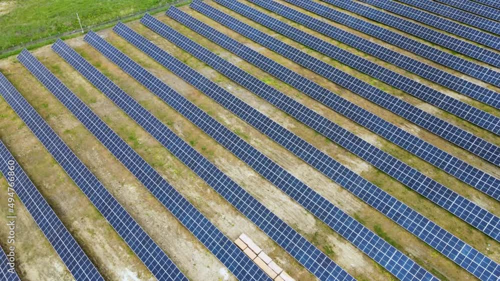 Aerial view of solar power plant on green field. Electric farm with panels for producing clean ecologic energy Aerial view of solar power plant on green field. Electric farm with panels for producing clean ecologic energy