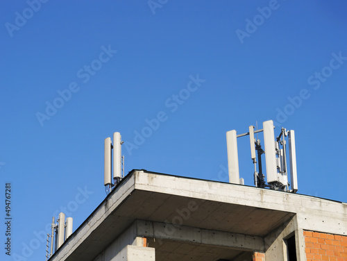A cell phone base on a roof of an unfinished building with the sky in the background