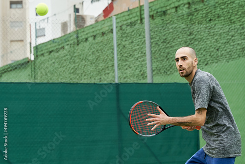 Tennis ball coming at player before forehand hit