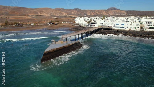 Aerial shot, surfers training surfing on the La Garita beach in Arrieta small coastal spanish village, famous place among locals and tourists, Lanzarote island. Canary, Spain. Travel concept 
 photo