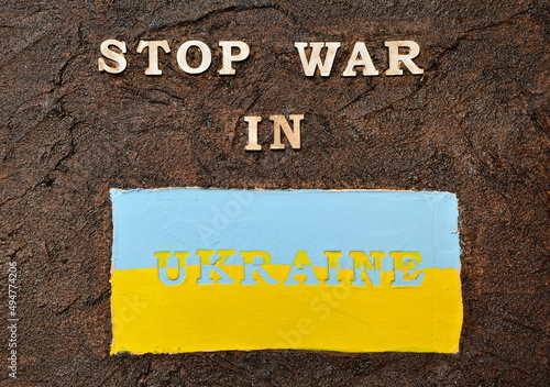 Text on a dark background. Stop the war in Ukraine. blue and yellow background. Plaster. Textured plaster. postcard. background. Ukraine. Conflict. War.