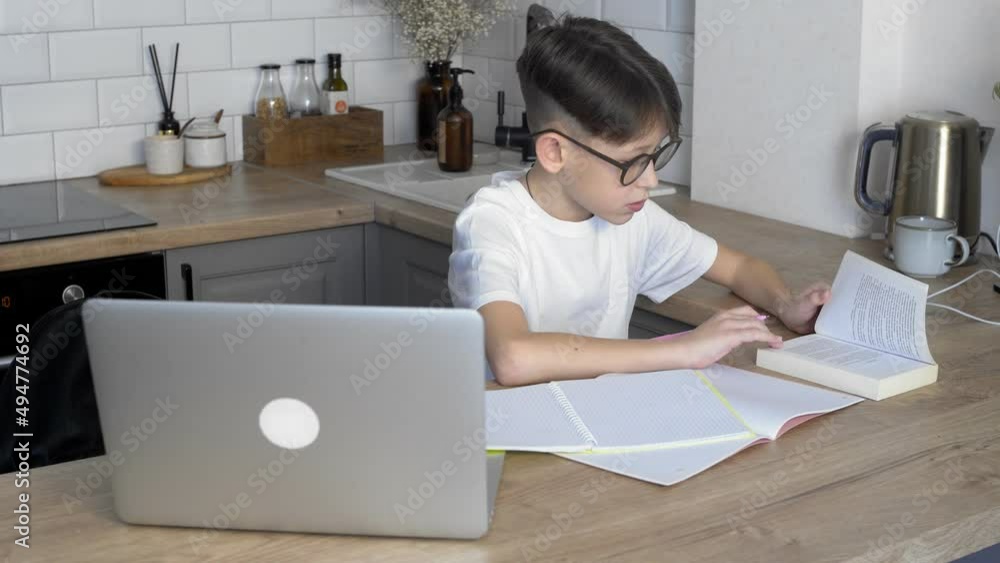 A boy with glasses is doing his homework. Study A boy with glasses is doing his homework. Study