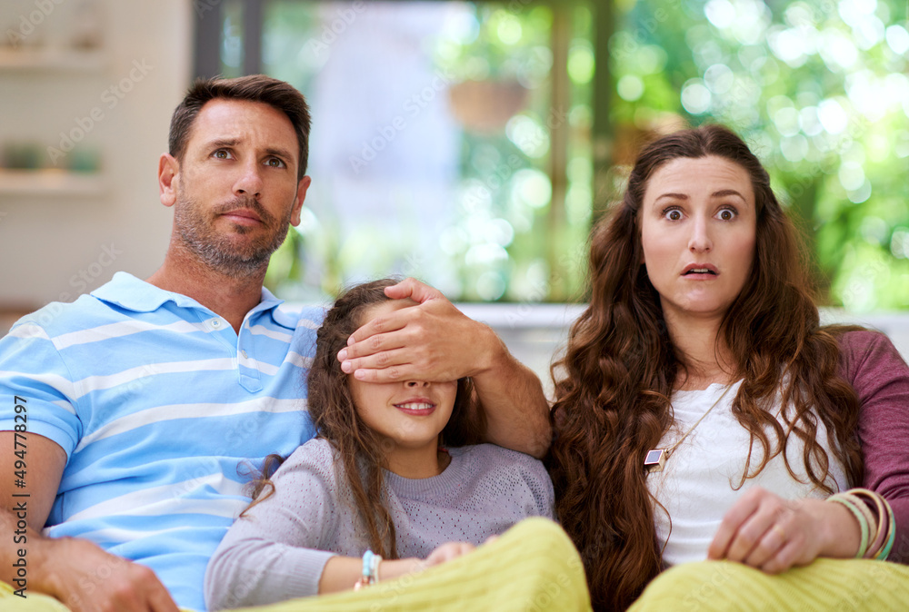 Dont look, honey. Cropped shot of a father covering his daughters eyes while watching a movie. Dont look, honey. Cropped shot of a father covering his daughters eyes while watching a movie.