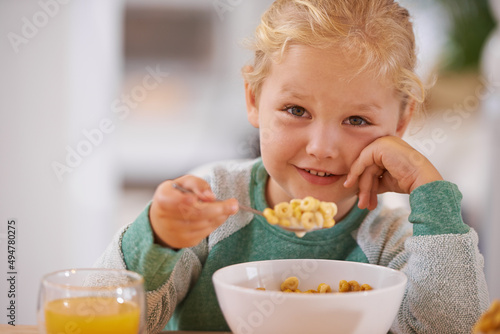 I made this myself. Portrait of a cute little girl eating breakfast at home.
