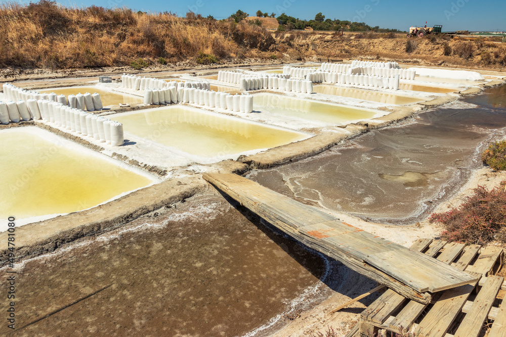 View of the Castro Marim salt pans in the Algarve, Portugal, with bags full of salt in the middle of a sunny day.
