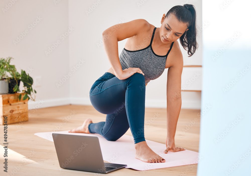 Fototapeta premium Relieving stress with fitness. Shot of a young woman practicing yoga at home.