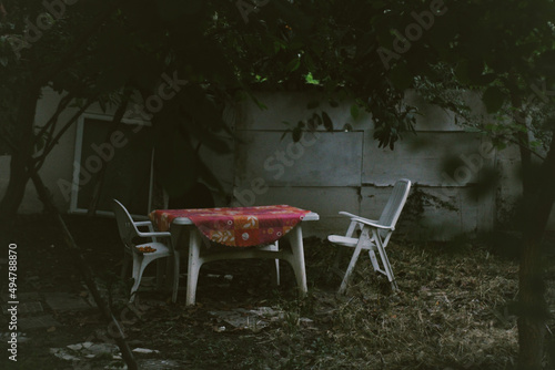 In the garden, there is an empty table and seats.