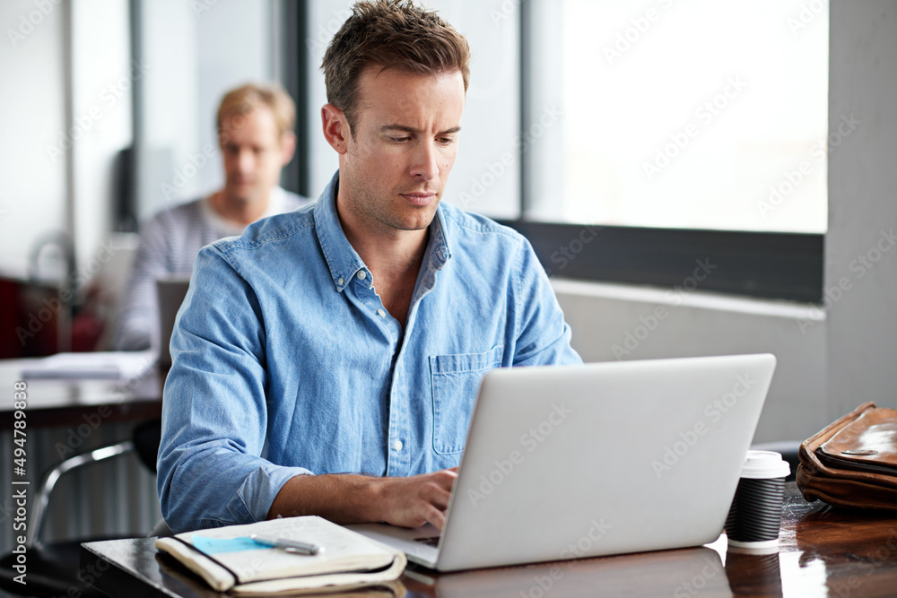 Deadlines are his inspiration. Shot of a man working on a laptop in an office. Deadlines are his inspiration. Shot of a man working on a laptop in an office.