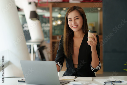 Successful business woman with coffee at office.