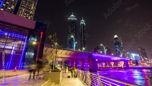 night illumination dubai water canal side walk fountain bridge panorama 4k time lapse uae photo