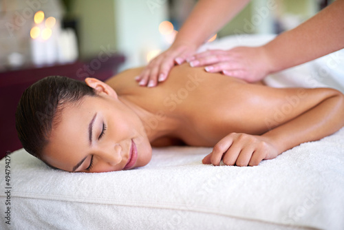 Fall into a relaxed, rejuvenated new you. Shot of a young woman enjoying a back massage at a spa.