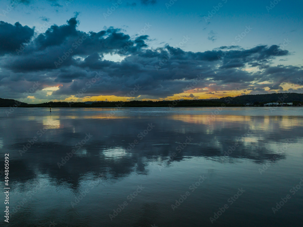 Sunrise waterscape and rain clouds reflections