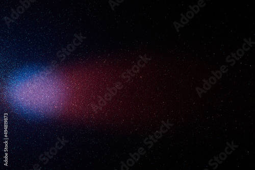 On a black background with multi-colored grain pink and light blue gradient wide beam of light