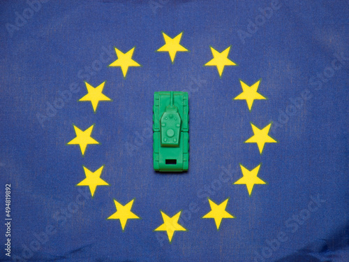 Ivanovo, Russia - 03.03.2022: selective focus on miniature of real tank on flag of  European Union: danger of military action, commonwealth and alliance overcoming humanitarian barriers  aggression