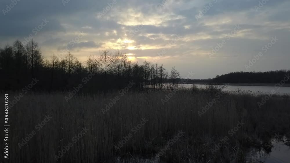 Gorgeous aerial flight fly backwards drone shot at romantic lovers place atspring sunset on a lake at a perfect wedding location in Brandenburg Germany. Cinematic nature view Gorgeous aerial flight fly backwards drone shot at romantic lovers place atspring sunset on a lake at a perfect wedding location in Brandenburg Germany. Cinematic nature view