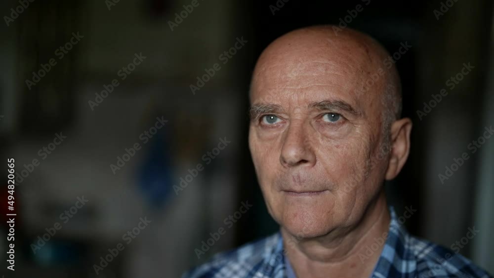portrait of an elderly bald man in a plaid shirt. the face is illuminated portrait of an elderly bald man in a plaid shirt. the face is illuminated