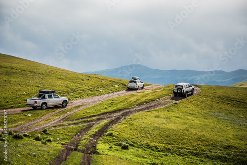 cars is moving along a dirt road. travel by car in the mountains. rough road in the steppe. jeeps make their way through the desert