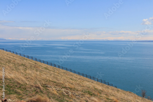 View of Lake Sevan and the fence standing on a sloping hill. Armenia 