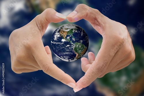human hands in heart shaped with blue Earth planet and blurred blue Earth planet background on save Earth concept, Earth image from NASA