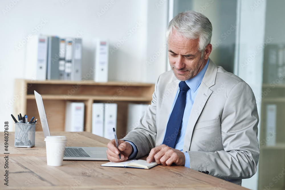 Getting down to business. Shot of a mature businessman working on a laptop in an office. Getting down to business. Shot of a mature businessman working on a laptop in an office.