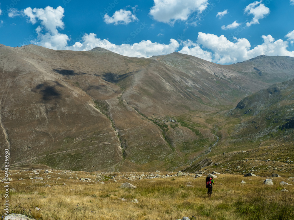 Hikers with backpacks descends into a valley.  mountains of turkey kackar. travel and adventure concept. 
