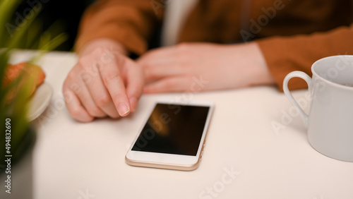 Female put a smartphone on white table