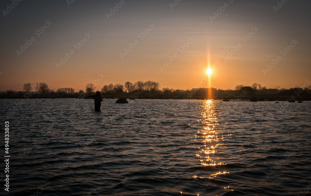 Angler fishing on the spring sunset Angler fishing on the spring sunset