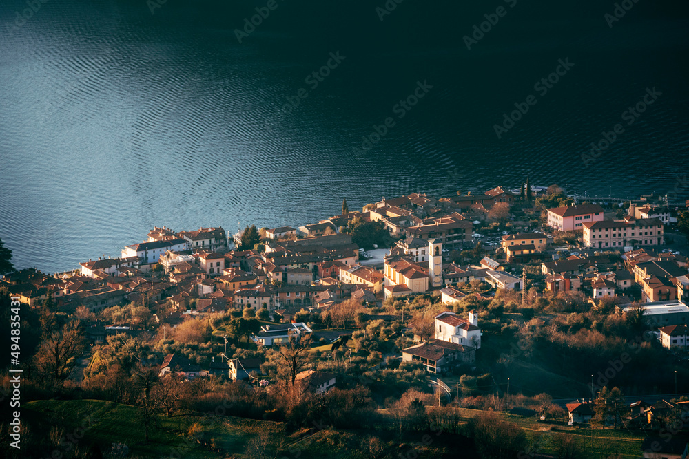 town on the side of lake iseo in italy at sunset