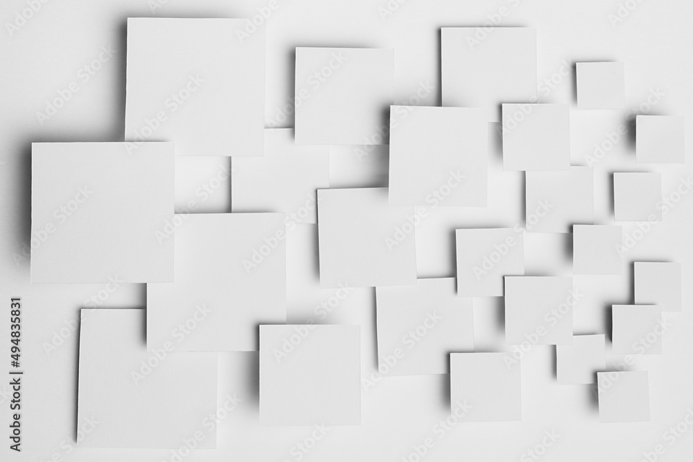 White abstract background - geometric pattern of different size squares in light with soft shadows, top view. Simple minimal backdrop for advertising, design.