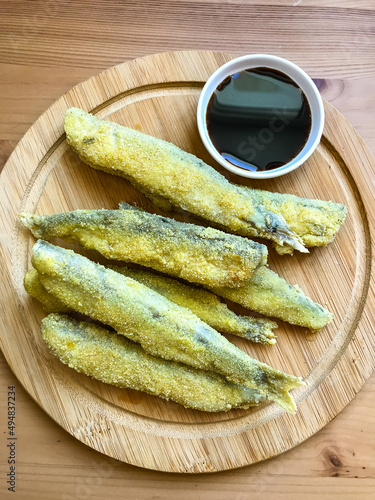 Pan fried fish on a plate. Capelin fried in oil with crispy breading.